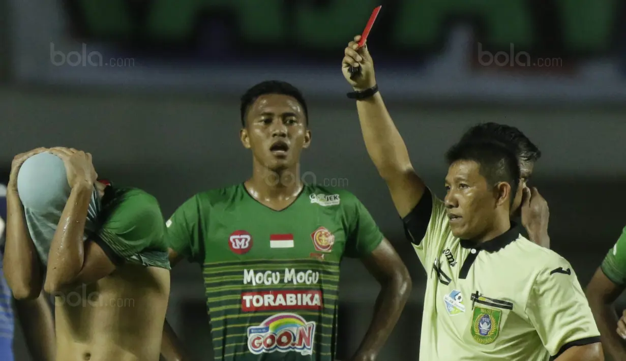 Pemain PS TNI, Safri Al Irfandi, mendapat kartu merah saat bertanding melawan Sriwijaya FC pada laga Liga 1 Indonesia di Stadion Pakansari, Bogor, Rabu, (25/10/2017). PS TNI menang 2-1 atas Sriwijaya FC. (Bola.com/M Iqbal Ichsan)