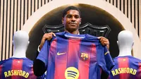 Marcus Rashford menunjukkan jersey Barcelona saat diperkenalkan sebagai pemain baru Balugrana untuk musim panas ini. (AFP/Josep Lago)