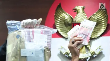 Petugas KPK menunjukan barang bukti uang tersangka penerimaan suap Dirjen Perhubungan Laut (Hubla) A Tonny Budiono dan Adiputra Kurniawan sebesar Rp 20,74 miliar saat konfrensi pers di Gedung KPK, Kamis (24/08). (Liputan6.com/Helmi Afandi)