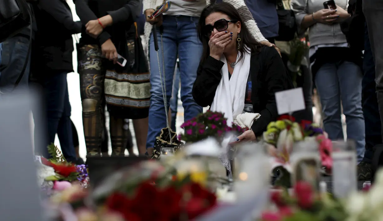 Seorang penggemar menangis di dekat bintang atas nama penyanyi legendaris David Bowie di Hollywood Walk of Fame di Los Angeles, Senin (11/1). Bowie meninggal di usia 69 tahun dan baru saja merilis album ke-25 nya yaitu "Blackstar" (REUTERS/ Mario Anzuoni)