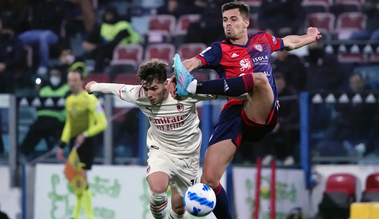 Gelandang AC Milan, Brahim Diaz berebut bola dengan pemain Cagliari, Alberto Grassi pada pertandingan lanjutan Liga Serie A Italia di Sardegna Arena di Cagliari, Italia, Minggu (20/3/2022). AC Milan menang atas Cagliari 1-0. (Alessandro Tocco/LaPresse via AP)