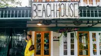 Aimee Cutter, pemilik restoran Beach House, berjalan menembus banjir kiriman dari Danau Pontchartrain di Lakeshore Drive, Mandeville, La., akibat dampak Badai Tropis Barry, Sabtu, 13 Juli 2019. (Matthew Hinton/AP)