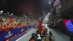 Pembalap Ferrari Sebastian Vettel berselebrasi di atas mobilnya setelah memenangkan balapan F1 GP Singapura di Sirkuit Jalan Marina Bay, Singapura (22/9/2019). Vettel kini memegang rekor kemenangan terbanyak di Singapura (2011, 2012, 2013, 2015,2019). (AP Photo/Lim Yong Teck)