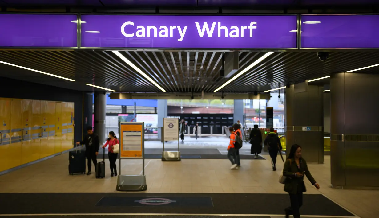 Penumpang berjalan di Stasiun Canary Wharf Elizabeth Line yang baru dibuka di London Timur, Inggris, Senin (7/11/2022). Awalnya jalur ini dibagi menjadi tiga bagian yang pusatnya justru terisolasi, sehingga membuat penumpang tidak dapat langsung ke kota dan harus transit di Stasiun Paddington atau Liverpool Street. (Daniel LEAL / AFP)