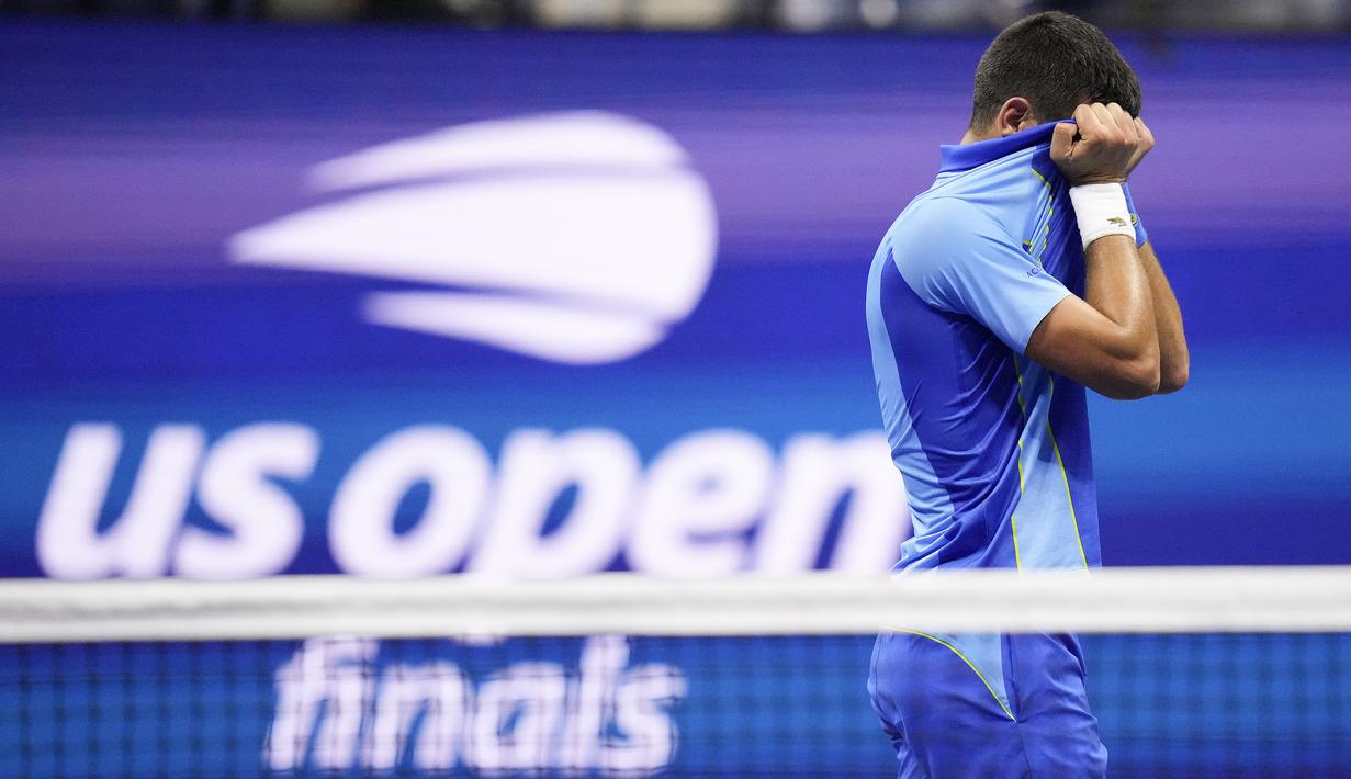 Petenis asal Serbia, Novak Djokovic, tak kuasa menahan tangis dengan menutupi wajahnya setelah berhasil merebut gelar juara US Open 2023 yang berlangsung di Arthur Ashe, New York, Senin (11/9/2023) pagi WIB. Novak Djokovic berhasil mengalahkan Daniil Medvedev yang berasal dari Rusia dengan skor 6-3, 7-6(7-5), 6-3. (AP Photo/Charles Krupa)