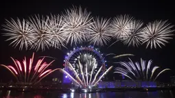 Kembang api meledak di atas kincir London Eye Ferris di Sungai Thames di London, untuk menandai awal tahun baru, Rabu (1/1/2020). (AP Photo/Matt Dunham)