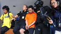 Polisi membawa tersangka pembunuhan satu keluarga di Kota Bekasi saat gelar perkara di Polda Metro Jaya, Jakarta, Jumat (16/11). Tersangka berinisial HS masih memiliki hubungan saudara dengan korban. (Merdeka.com/Imam Buhori)