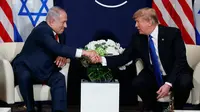 Presiden AS Donald Trump berjabat tangan dengan Perdana Menteri Israel Benjamin Netanyahu saat bertemu di sela Forum Ekonomi Dunia, Davos (25/1). (AP Photo / Evan Vucci)