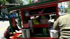 Seorang emak-emak yang juga PKL menangis saat gerobak ketopraknya dibawa oleh Satpol PP dalam sebuah razia.