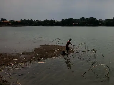 Warga memancing di perkampungan budaya betawi Setu Babakan di Jakarta Selatan, Selasa (17/3/2020). Sepinya kawasan Setu Babakan merupakan imbas dari kebijakan Pemprov DKI Jakarta yang menutup sejumlah tempat wisata sebagai upaya pencehagan covid-19. (Liputan6.com/Immanuel Antonius)