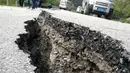 Jalanan yang terbelah yang disebabkan gempa di sebuah jalan di Jiuzhaigou di provinsi Sichuan barat daya China (9/8). Sedikitnya 12 orang tewas ketika sebuah gempa berkekuatan 6,5 skala Richter melanda China barat day. (AFP Photo/Str/China Out)