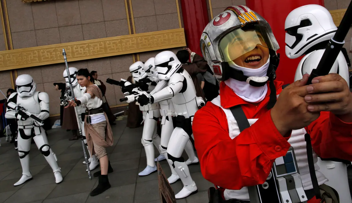 Seorang pria mengenakan kostum karakter Star Wars, Poe Dameron, berselfie dengan latar belakang Storm Troopers selama perayaan Star Wars Day di Taipei, Taiwan, Rabu (4/5). (REUTERS/Tyrone Siu)