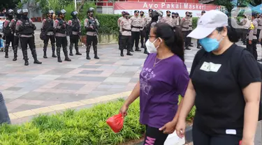 Aparat kepolisian bersenjata lengkap bersiaga di kawasan Bundaran Hotel Indonesia (HI),  Jakarta, Rabu (12/5/2021). Pengamanan ketat tersebut dilakukan untuk menjaga perayan Idul Fitri 1442 di jantung Ibu Kota. (Liputan6.com/Angga Yuniar)