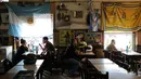 Warga mengunjungi restoran Ribera Sur di lingkungan La Boca, ibu kota Argentina, Buenos Aires pada 27 November 2018. Kota ini dikenal sebagai markas dari Boca Juniors, tim yang pernah membesarkan Diego Maradona. (Ludovic MARIN / AFP)