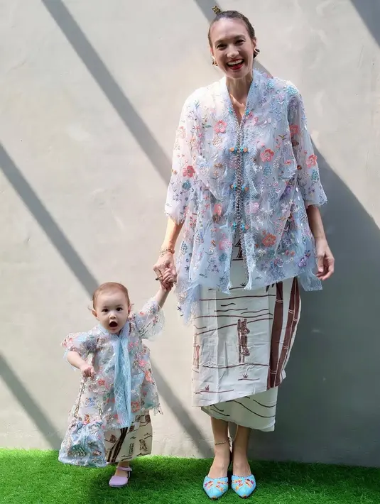 Dengan wajah bule dari Nadine Chandrawinata, Djiwa terlihat menggemaskan dengan kebaya modifikasi. Kebaya brukat sky blue dengan bordir bunga pastel dipadukan dengan rok print yang senada dengan sang ibu. [@nadinelist]