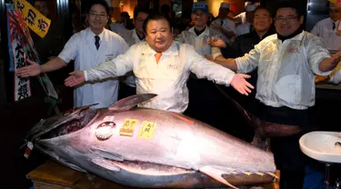 CEO Sushi Zanmai, Kiyoshi Kimura berpose dengan ikan tuna seberat 212 kg di depan restorannya, dekat pasar ikan Tsukiji, Tokyo, Kamis (5/1). Dalam pelelangan pertama tahun 2017, ikan tuna itu terjual 74,2 juta yen (212 kilogram). (TOSHIFUMI KITAMURA/AFP)