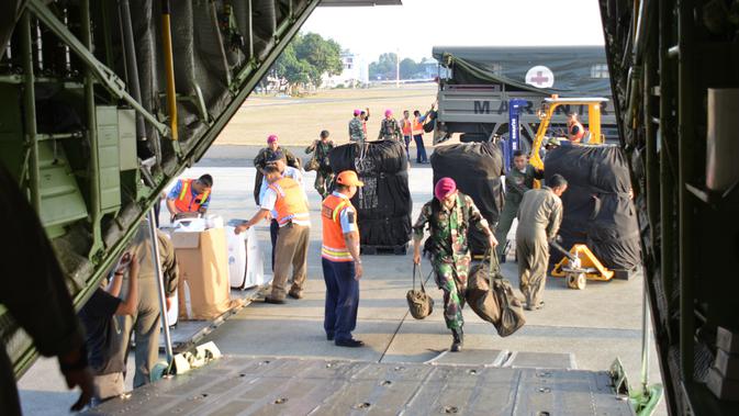 Satgas Pasukan Reaksi Cepat Penanggulangan Bencana (PRCPB) Marinir memasukkan logistik bantuan ke dalam pesawat angkut C-130 Hercules TNI Angkatan Udara menuju Lombok dari Lanud Halim Perdanakusuma, Jakarta, Senin (6/8). (Liputan6.com/HO/Dispen Kormar)