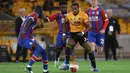 Gelandang Wolverhampton Wanderers, Adama Traore, berebut bola dengan gelandang Crystal Palace, Jeffrey Schlupp, pada laga lanjutan Premier League di Molineux Stadium, Selasa (21/7/2020) dini hari WIB. Wolves menang 2-0 atas Crystal Palace. (AFP/Martin Rickett/pool)
