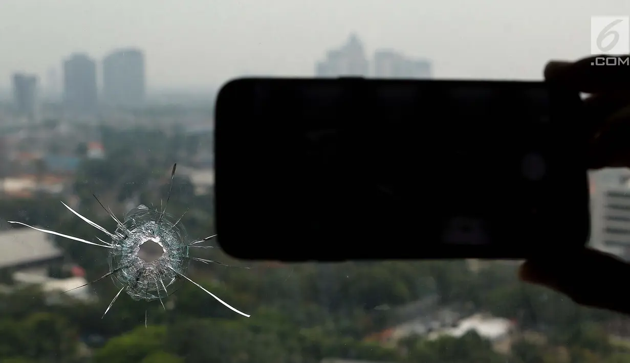 Kaca yang terkena peluru nyasar di lantai 16 nusantara I, Kompleks Parlemen MPR/DPR-DPD, Jakarta, Selasa (16/10). Kepolisian sementara menyimpulkan peluru nyasar tersebut  dimana sedang ada latihan menembak dari Perbakin. (Lipiutan6.com/Johan Tallo)
