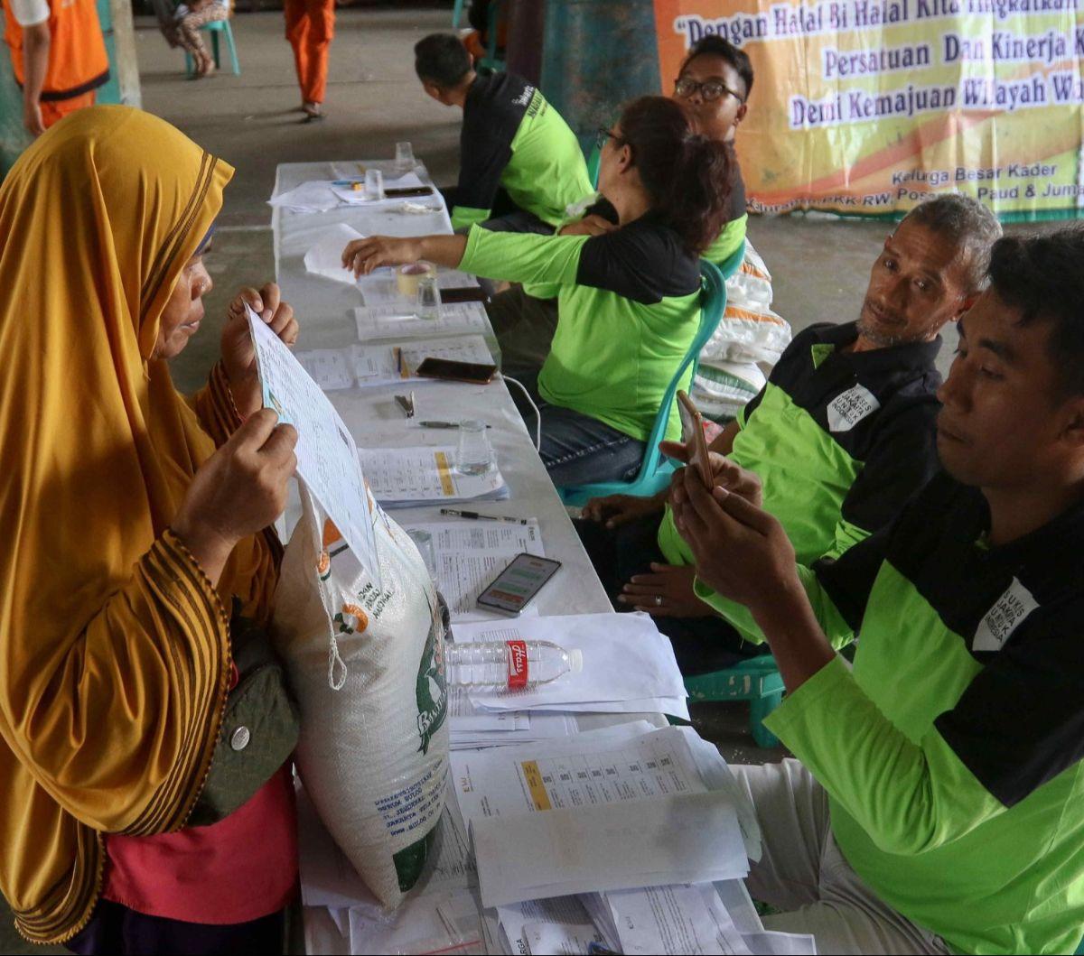 Petugas memeriksa data warga penerima Bantuan Sosial (Bansos) Cadangan Beras Pemerintah (CBP) di kawasan Warakas, Tanjung Priok, Jakarta Utara, Selasa (20/2/2024). Sebanyak 1.000 karung bantuan Cadangan Beras Pemerintah disalurkan kepada warga di Keluraha