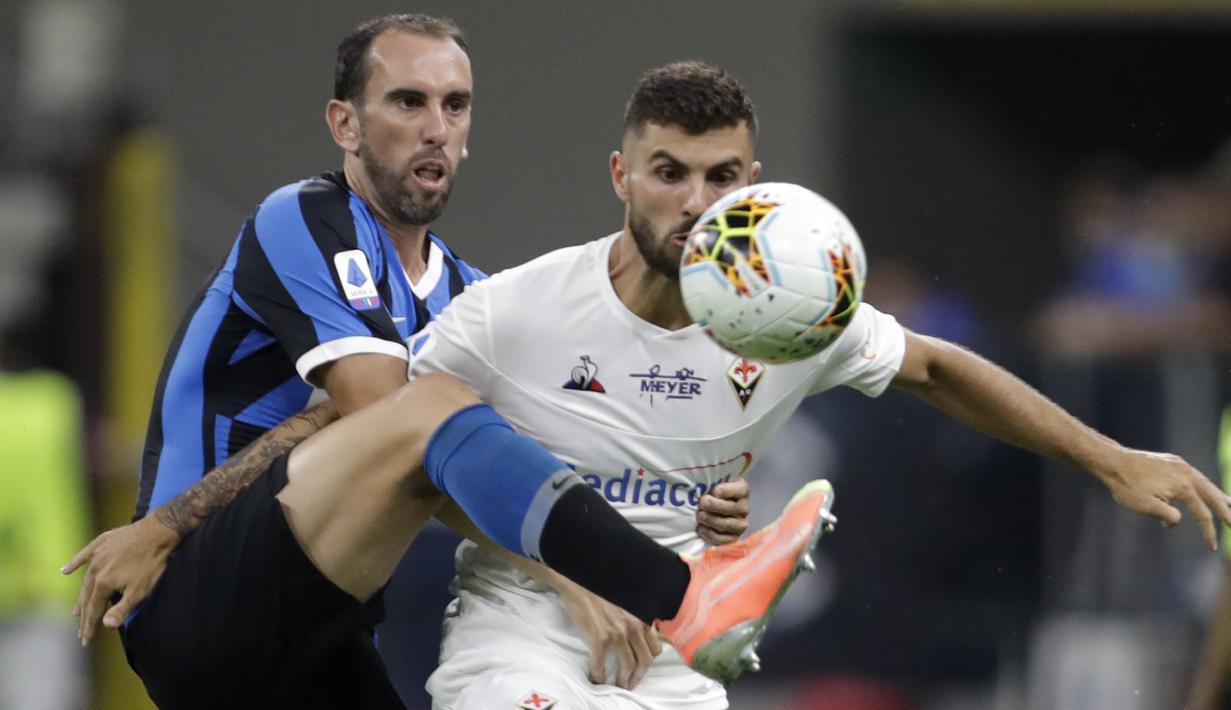 Bek Inter Milan, Diego Godin, berebut bola dengan pemain Fiorentina, Patrick Cutrone, pada laga Serie A di Stadion di Giuseppe Meazza, Rabu (22/7/2020). Kedua tim bermain imbang 0-0. (AP Photo/Luca Bruno)