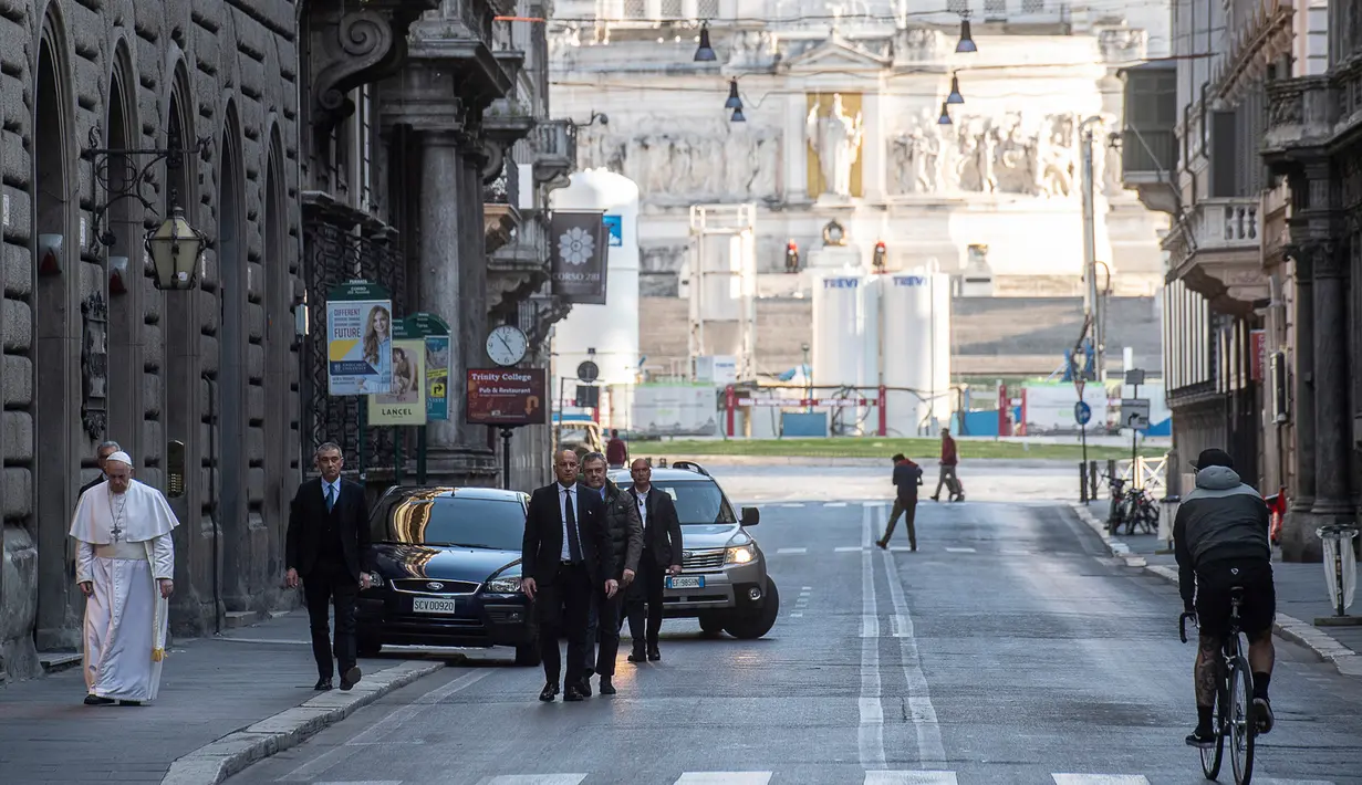 Paus Fransiskus berjalan menuju St. Marcello al Corso di Roma, Italia, Minggu (15/3/2020). Di tengah lockdown akibat virus corona COVID-19, Paus meninggalkan Vatikan dan mengunjungi Basilica of Santa Maria Maggiore serta St. Marcello al Corso untuk berdoa. (Vatican News via AP)