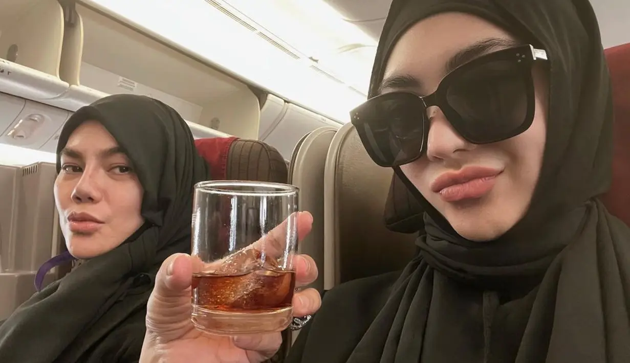 Dalam pesawat saat berangkat ke Tanah Suci, Sarita Abdul Mukti dan Shania Salsabila sudah kompak dalam berpakaian. Mereka kerap tampil dengan warna yang sama. (Foto: Instagram/@_shaniasalsabila)
