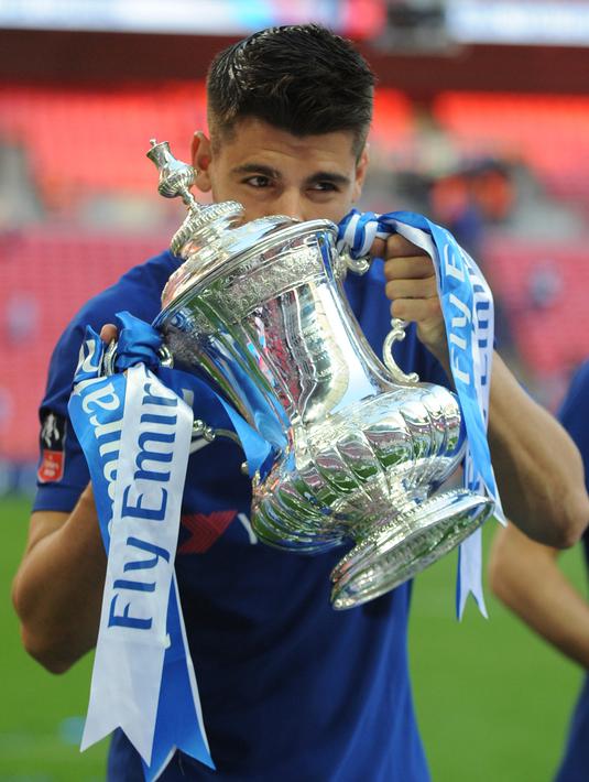Penyerang Chelsea, Alvaro Morata mencium trofi Piala FA usai pertandingan melawan Manchester United pada babak final Piala FA di stadion Wembley di London (19/5). Chelsea mengalahkan MU 1-0. (AP Photo / Tim Ireland)