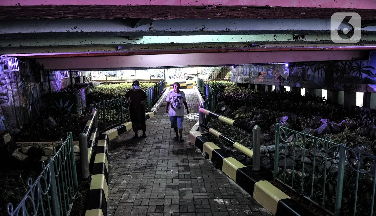 Pejalan kaki melintas di taman kolong Jembatan Pegangsaan, Jakarta, Minggu (7/2/2021). Sebelumnya taman ini merupakan lapak warga tunawisma yang kemudian ditertibkan dan disulap menjadi taman usai Menteri Sosial Risma blusukan pada akhir Desember 2020. (merdeka.com/Iqbal S Nugroho)