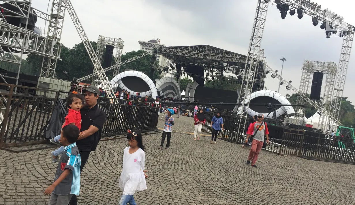 Pengunjung beraktivitas di sekitar panggung malam Tahun Baru 2018 di Monas, Jakarta, Sabtu (30/12). Dari tahun ke tahun, Monas sebagai salah satu ikon Ibu Kota, menjadi titik pusat perayaan pergantian tahun. (Liputan6.com/Immanuel Antonius)