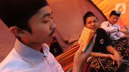 Santri membaca Al-Qur'an saat kegiatan Kemah Hari  Santri di Bogor, Selasa (22/10/2019). Pemerintah menetapkan 22 Oktober sebagai HSN bertepatan dengan Resolusi Jihad yang dikumandangkan  pendiri Nahdlatul Ulama KH. Hasyim Asyari untuk mempertahankan kemerdekaan RI. (merdeka.com/Arie Basuki)