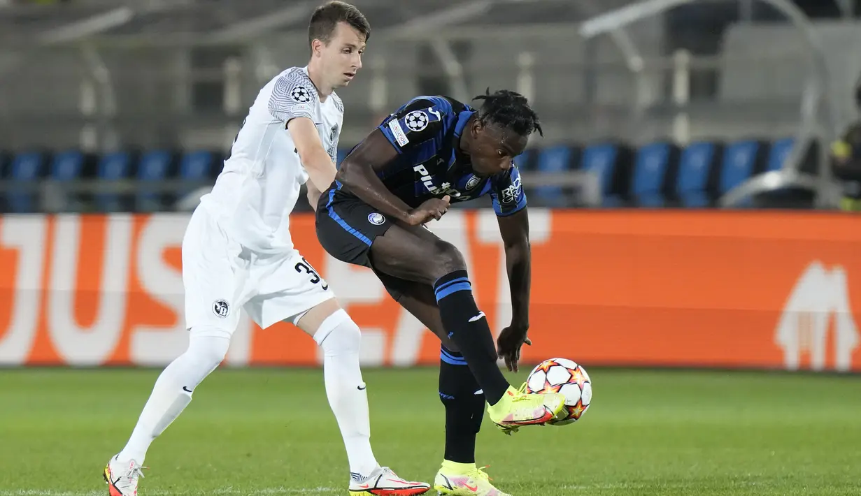 Penyerang Atalanta, Duvan Zapata berusaha mengontrol bola dari kawalan pemain Young Boys, Sandro Lauper selama pertandingan grup F Liga Champions di Stadion Gewiss di Bergamo, Italia, Kamis (30/9/2021). Hasil ini membuat Atalanta berada di puncak klasemen dengan empat poin. (AP Photo/Luca Bruno)