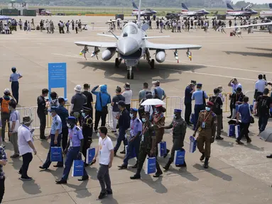 Perwira militer asing dan pengunjung berjalan melewati jet tempur J-10C dari Angkatan Udara Tentara Pembebasan Rakyat China (PLA) yang dipamerkan selama Airshow China 2021 di Zhuhai di provinsi Guangdong, China (38/9/2021). (AP Photo/Ng Han Guan)