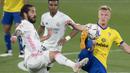 Gelandang Real Madrid, Isco (kiri) berebut bola dengan gelandang Cadiz, Jens Jonsson pada laga Liga Spanyol 2020/2021 di Ramon de Carranza Stadium, Cadiz (21/4/2021). Setelah membela Real Madrid selama 9 musim sejak 2013/2014 dan tampil dalam 353 laga dengan torehan 53 gol dan 57 assist, Isco yang sukses mempersembahkan 3 gelar La Liga dan 5 trofi Liga Champions harus angkat kaki secara gratis menuju Sevilla pada awal musim 2022/2023. (AFP/Jorge Guerrero)