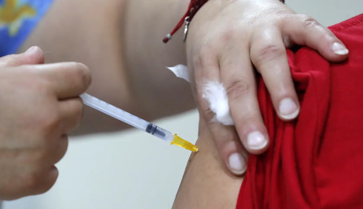 Seseorang disuntik dosis vaksin COVID-19 Pfizer-BioNTech di pusat vaksinasi di Santiago, Chile, Senin (10/1/2022). Chile mulai memberikan dosis keempat vaksin COVID-19 kepada warga berusia di atas 12 tahun yang mengalami gangguan kekebalan. (Javier TORRES / AFP)