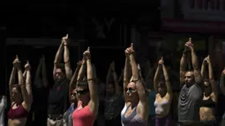 Peserta berpartisipasi dalam yoga outdoor di kawasan Times Square, New York saat Summer Solstice atau hari dengan siang terpanjang di musim panas, Kamis (21/6). Acara itu menandai Hari Yoga Internasional yang jatuh pada 21 Juni (TIMOTHY A. CLARY/AFP)