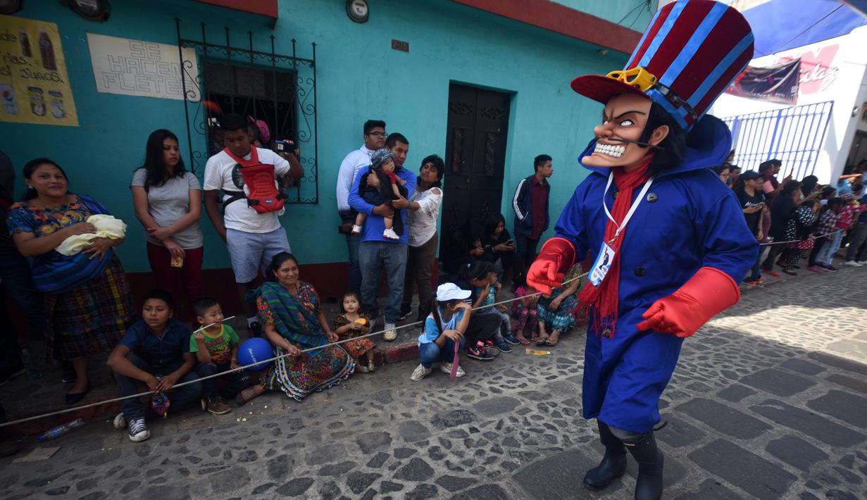 Anggota Saturno Club dengan kostum Dick Dastardly melakukan parade Dance of Costumes tahunan di sepanjang jalan kota Sumpango, Guatemala, Senin (30/12/2019). Parade kostum yang menampilkan karakter televisi dan film ini untuk memeriahkan malam pergantian tahun. (ORLANDO ESTRADA/AFP)