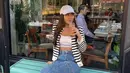 Ngopi ala New Yorker, Aaliyah pilih tampil minimalis dengan sport bra Calvin Klein dan bawahan denim. Striped cardigan dan topi putih jadi pelengkap outfit [@aaliyah.massaid]