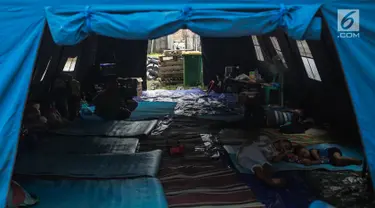 Suasana tenda pengungsian korban rumah ambles di Lodan Raya, Pademangan, Jakarta Utara, Kamis (22/11). Sebanyak delapan kepala keluarga (KK) diungsikan akibat rumah mereka ambles kena imbas pengerukan Anak Kali Ciliwung. (Liputan6.com/Faizal Fanani)