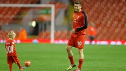 Gelandang Liverpool Adam Lallana bermain bola dengan anaknya di dalam lapangan usai bertanding melawan Chelsea pada pertandingan Liga Inggris di Anfield, Liverpool, 12 Mei 2016. (Reuters / Carl Recine)