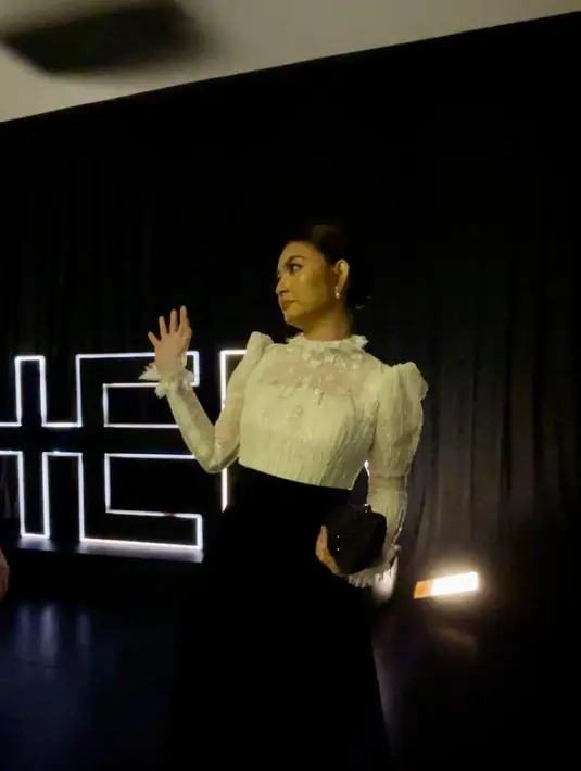 Selvi kemudian melengkapi penampilannya dengan heels dan clutch warna hitam senada. [Foto: Fimela/Hilda Irach]