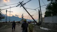 Orang-orang berjalan di sepanjang pantai setelah gempa bumi dan tsunami yang kuat menghantam Kota Palu di Sulawesi Tengah, Sabtu (29/9). Dampak dari bencana tersebut melulunlantakkan bangunan dan ratusan jiwa meninggal dunia. (AFP/Bay ISMOYO)