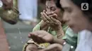 Umat Hindu meminum Tirta (air suci) saat persembahyangan Hari Raya Galungan di Pura Aditya Jaya, Rawamangun, Jakarta, Rabu (19/2/2020). Hari Raya Galungan yang merupakan hari kemenangan kebenaran (Dharma) atas kejahatan (Adharma) itu dirayakan setiap 210 hari sekali. (merdeka.com/Iqbal Nugroho)