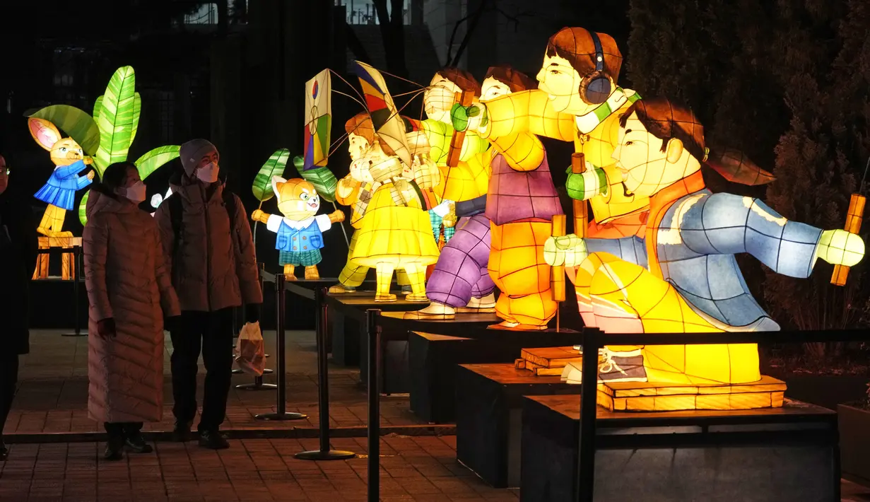 Sepasang suami istri menikmati deretan lentera selama perayaan Tahun Kelinci 2023 mendatang di Lapangan Gwanghwamun, Seoul, Korea Selatan, Senin (19/12/2022). Festival Lentera ini akan berlangsung dari 19-31 Desember 2022. (AP Photo/Ahn Young-joon)