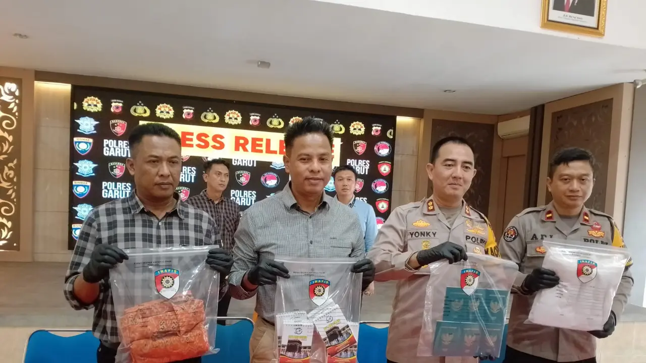 Kapolres Garut AKBP Rohman Yonky Dilatha,bersama Kasatreskrim Ari Rinaldo dalam rilis kasus gagal berangkat umroh di Mapolres Garut, Jawa Barat. (Liputan6.com/Jayadi Supriyadin)
