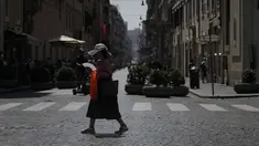 Seorang wanita melambaikan kipasnya saat berjalan di pusat kota Roma, Selasa, 22 Agustus 2023. (AP Photo/Gregorio Borgia)