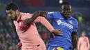 Striker Barcelona, Luis Suarez, berebut bola dengan pemain Getafe, Djene, pada laga La Liga di Stadion Alfonso Perez, Minggu (6/1). Barcelona menang 2-1 atas Getafe. (AP/Manu Fernandez)