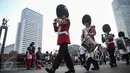 Scotts Guard alias penjaga Buckingham Palace melakukan aksi mengelilingi di Bundaran HI, Jakarta, Minggu (5/6). Aksi Scotts Guard yang didatangkan dari Inggris ini dalam rangka hari ulang tahun Ratu Elizabeth II yang ke-90. (Liputan6.com/Faizal Fanani)