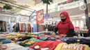 Pekerja menata pakaian dengan potongan harga atau diskon di pusat perbelanjaan kawasan Jakarta, Rabu (14/12/20222). Menjelang akhir tahun dan perayaan natal pusat-pusat perbelanjaan mulai menawarkan diskon guna menarik pengunjung. (Liputan6.com/Faizal Fanani)