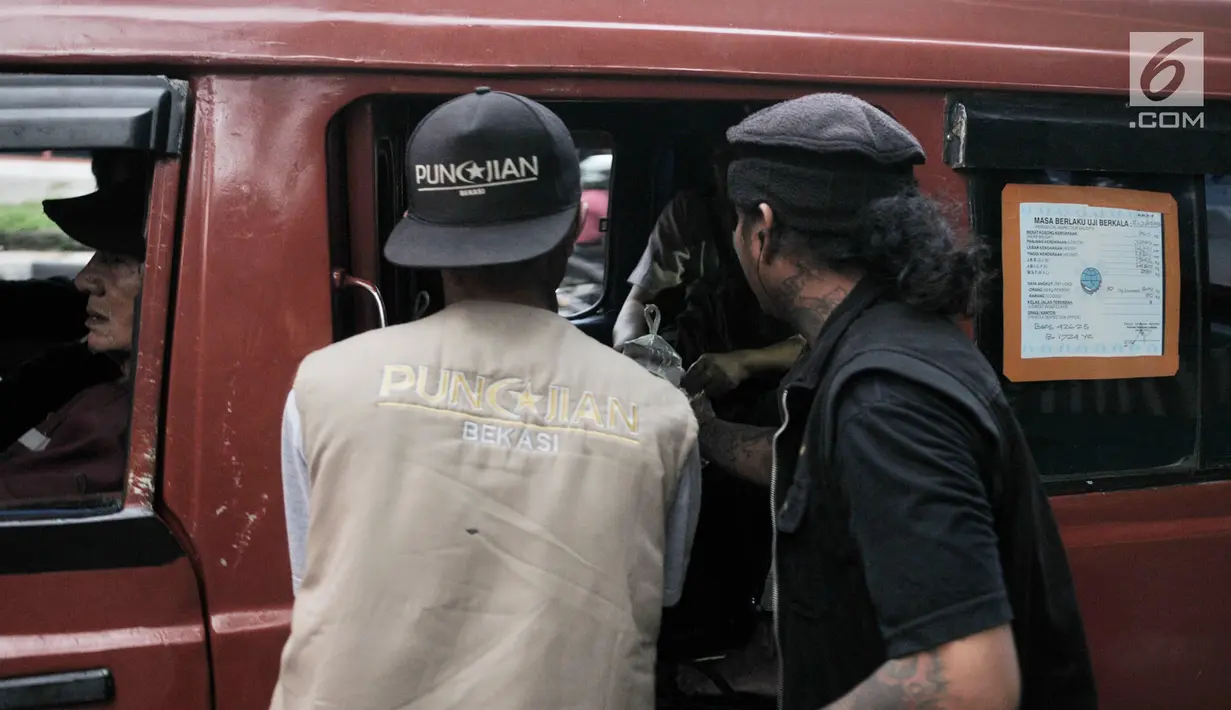 Sejumlah anak punk yang tergabung dalam komunitas Punkajian Bekasi dan FAM-US membagikan takjil kepada penumpangangkot di Bekasi, Jawa Barat, Rabu (15/5/2019). Punkajian Bekasi bersama FAM-US membagikan takjil kepada pengendara yang melintas di kawasan tersebut. (merdeka.com/Iqbal Nugroho)